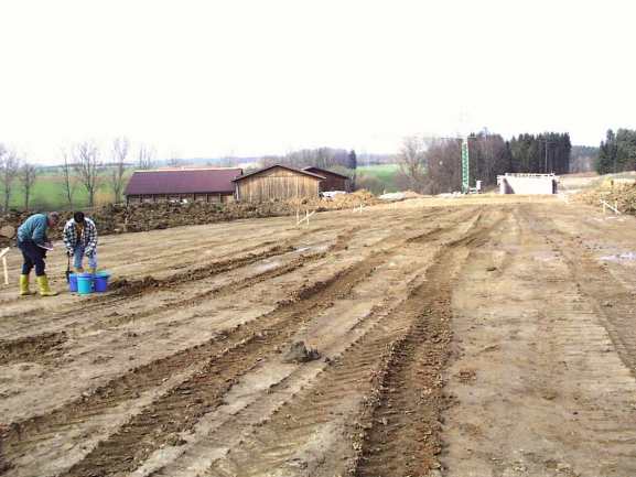 große sandige Baustellenfläche mit Reifenspuren